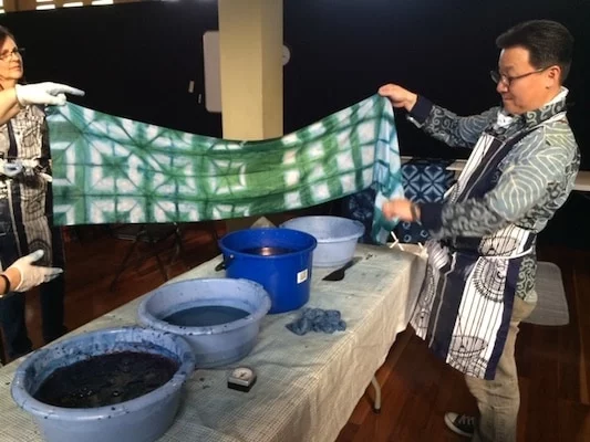Shuji Yamazaki pulling a piece out of the indigo dye bath.